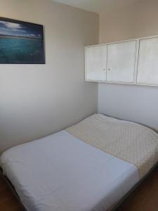 a small bedroom with a bed with a picture on the wall at Le Grand Large in Gruissan