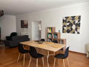 a living room with a wooden table and chairs at La casa Marcel, maison de 110 m2 in Pia