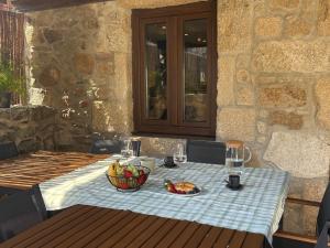 a table with a bowl of fruit on a blue table cloth at A Casa da aldea de Iria in Padrón +34 photos