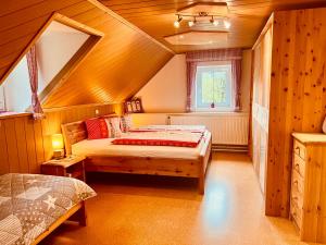 a attic bedroom with a bed and a window at Ferienhof Hintergrabenbauer in Spital am Pyhrn