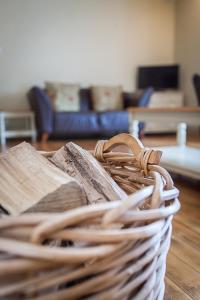 una pila de libros en una cesta de mimbre en Stoodleigh Court Coach House, en Tiverton