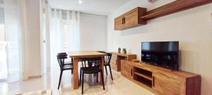 a living room with a table and a flat screen tv at Piso 3 habitaciones en Pescadores, 6 in Peniscola