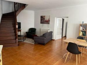 a living room with a couch and a table at La casa Marcel, maison de 110 m2 in Pia