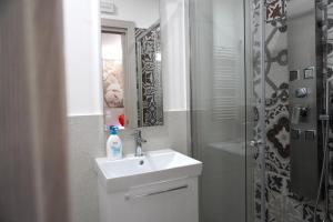 a white bathroom with a sink and a shower at Il corallo azzurro in Reggio di Calabria +15 photos