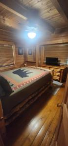 a bedroom with a bed in a wooden cabin at The Bears Den in Gatlinburg