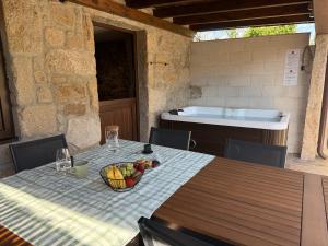 a table with a bowl of fruit and a tub at A Casa da aldea de Iria in Padrón