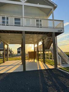 a large building with a deck and stairs on it at Beach House with Breathtaking Sunsets - Perfect for Couples and Families! in Bolivar Peninsula