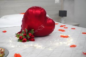 a bouquet of red flowers sitting on a bed at Il corallo azzurro in Reggio di Calabria