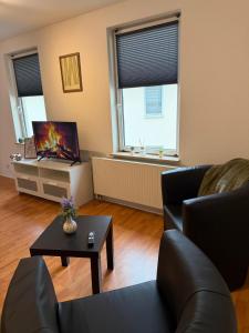 a living room with a couch and a tv at Apartment Kompakt Gottschalk 5,0 in Kassel +2 photos