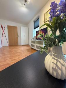 a vase with purple flowers sitting on a table at Apartment Kompakt Gottschalk 5,0 in Kassel