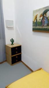 a bedroom with a dresser and a painting on the wall at Buonavacanza in Erice
