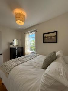 a bedroom with a large white bed with a window at Little Banook B&B in Halifax