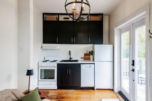 a kitchen with black cabinets and a white refrigerator at Little Banook B&B in Halifax