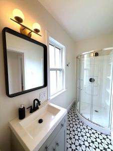 a bathroom with a sink and a shower with a mirror at Little Banook B&B in Halifax +13 photos