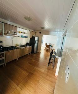 a large kitchen with wooden cabinets and a dining room at casapraia penha sc in Penha
