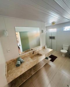 a bathroom with a large sink and a toilet at casapraia penha sc in Penha +11 photos