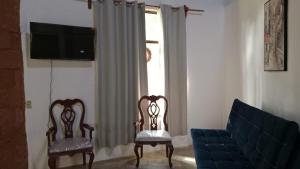 a living room with two chairs and a couch at Quinta Corona Hospedaje Familiar in Oaxtepec