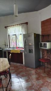 a kitchen with a stainless steel refrigerator and a table at Quinta Corona Hospedaje Familiar in Oaxtepec