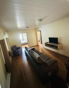 a living room with a couch and a flat screen tv at casapraia penha sc in Penha