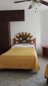 a bedroom with a bed with a yellow blanket at Quinta Corona Hospedaje Familiar in Oaxtepec +26 photos