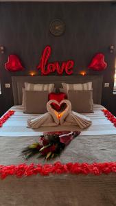 a bedroom with a bed with a love sign on the wall at Hammam du château in Francheville +4 photos