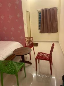 a room with two chairs and a table and a bed at KH Residency And Lodging in Punganūru
