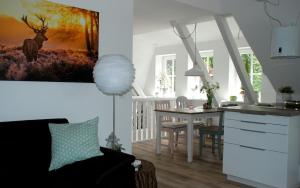 a kitchen and living room with a table and a deer painting at Ferienwohnung am Eichenpark, Lüneburger Heide in Egestorf