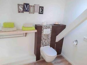 a bathroom with a white toilet and a staircase at Ferienwohnung am Eichenpark, Lüneburger Heide in Egestorf