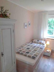 a bedroom with a bed and a window at Ferienwohnung am Eichenpark, Lüneburger Heide in Egestorf
