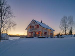 a house in the snow with the sunset in the background at Vasekoja Holiday Complex in Möldri