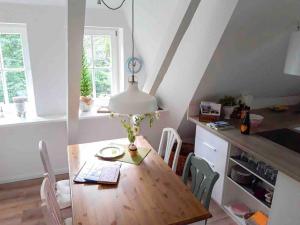 a dining room with a wooden table and chairs at Ferienwohnung am Eichenpark, Lüneburger Heide in Egestorf +9 photos