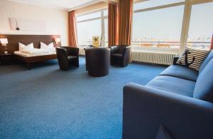 a hotel room with a couch and a bed at Hotel Restaurant Seestern in Heiligenhafen