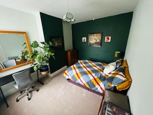 ein Schlafzimmer mit grünen Wänden und einem Bett und einem Schreibtisch in der Unterkunft Murray Road in Rugby