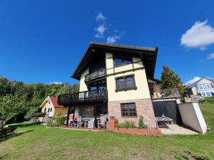 a large house with a balcony on a hill at Sonnige Aussicht in Mitlosheim