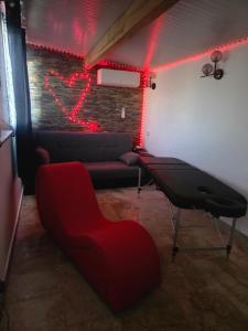 a living room with a couch and red lights at love room les plaisirs partagés in Arles