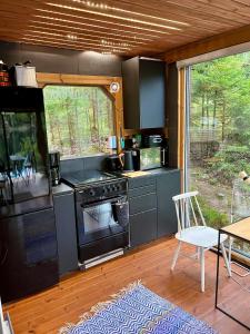 a kitchen with a stove and a table and a chair at Nordic Experience Nuuksio Sauna in Nuuksio