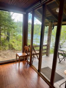 a screened in porch with a chair and a table at Nordic Experience Nuuksio Sauna in Nuuksio