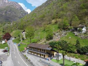 a building on the side of a road next to a mountain at Osteria Posse in Lavertezzo