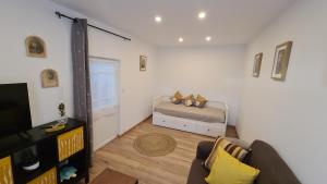a living room with a bed and a television at Chez Mémère Paulette in Châtres-sur-Cher