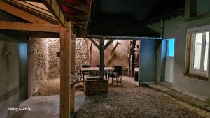 a patio with a table and chairs in a building at Chez Mémère Paulette in Châtres-sur-Cher