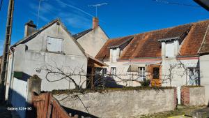 an old white house with a fence in front of it at Chez Mémère Paulette in Châtres-sur-Cher