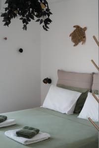 a bed with green and white pillows and a plant at Azura creta in Gra Liyiá