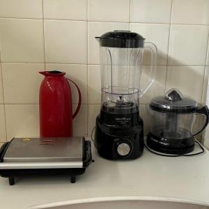 a blender sitting on a counter next to a red pitcher at Casa Jauá ParaisodePainho in Camaçari