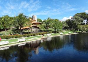 a park with benches and a lake and a building at Casa Jauá ParaisodePainho in Camaçari