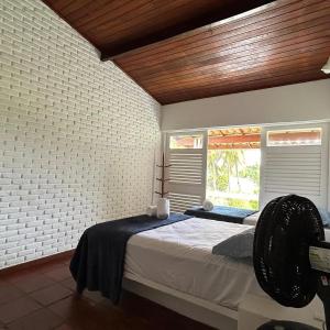 a bedroom with a large bed and a window at Casa Jauá ParaisodePainho in Camaçari