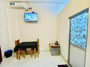 ein Esszimmer mit einem Tisch und einem Fernseher in der Unterkunft Ranmudu Hotel in Hanwella