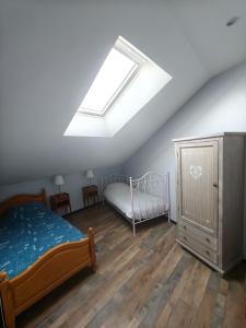 a attic bedroom with a bed and a skylight at Duplex climatisé in Aramits