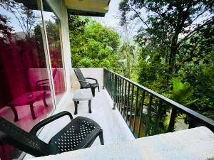 ein Balkon mit zwei Stühlen und einem Tisch darauf in der Unterkunft Ranmudu Hotel in Hanwella + 7 Fotos