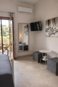 a room with a bed and a table and a mirror at Nikos & Vivi Studios in Perivólion