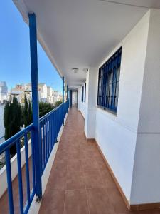 a balcony of a building with blue railing and a walkway at Apartamento Morro de Gos Ref067 in Oropesa del Mar